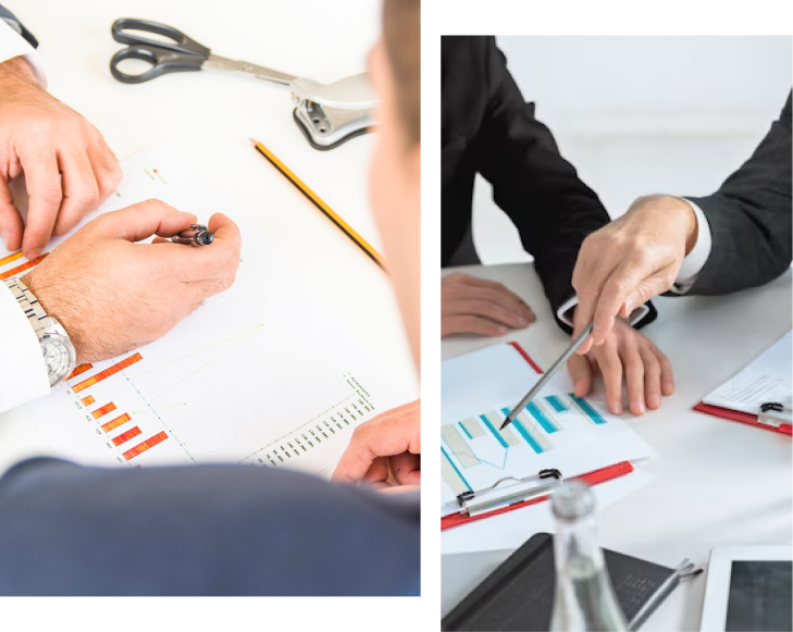 Two sets of hands are pointing at various charts and graphs on paper during a business meeting.