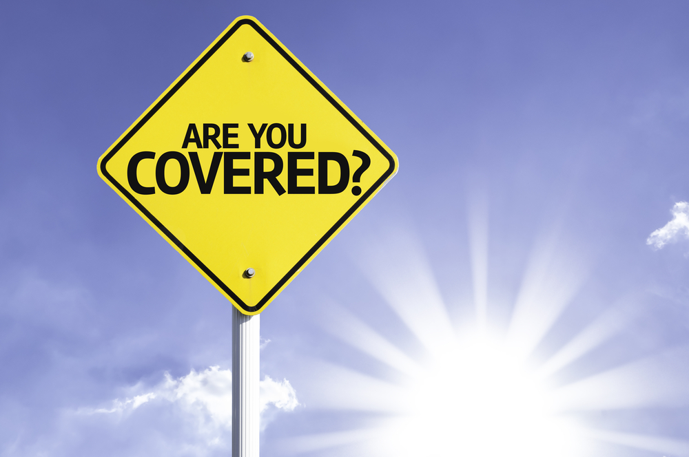 A yellow road sign with the text "ARE YOU COVERED?" is shown against a blue sky