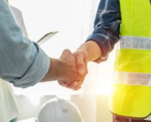 Two individuals shake hands, indicating a critical discussion about insurance and risk management.