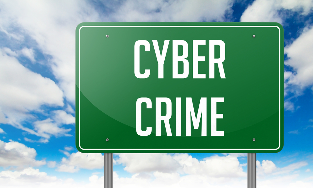 A green road sign with the bold text "CYBER CRIME" stands out against a cloudy sky background