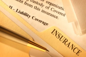 Close-up of insurance documents with a section labeled "Liability Coverage" and a pen resting on top.