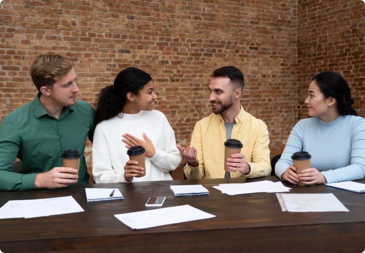 Four people sit around a table Discussing insights from leading risk advisory firms in Florida, they delve into strategies for their next big project.