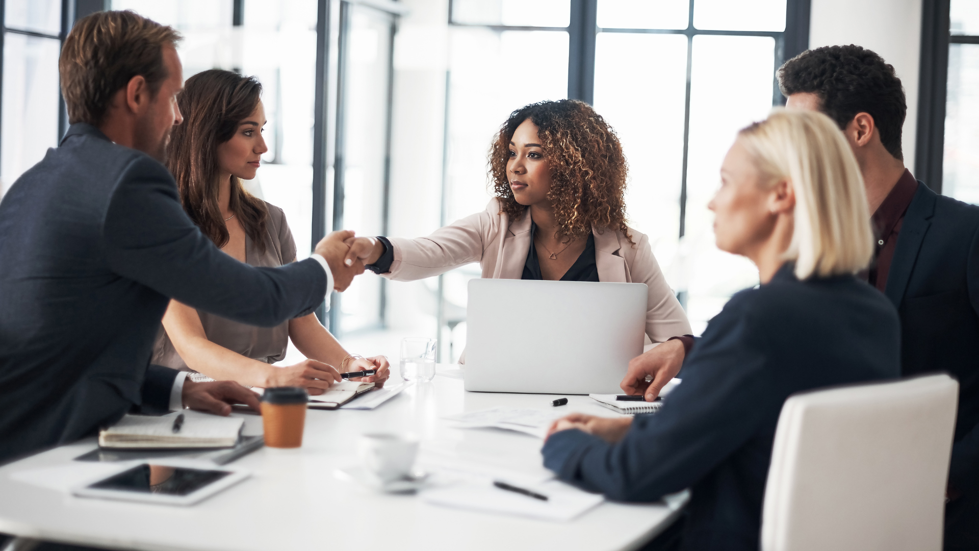 A group of five business professionals, including a certified risk management consultant from Florida, sit around a table in an office.