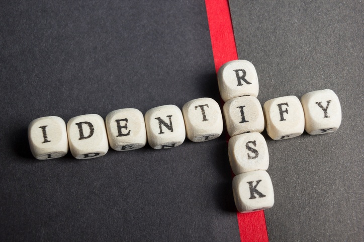 Cubes with letters arranged to form the words "IDENTIFY" horizontally and "RISK" vertically, perfect for illustrating risk assessment concepts.