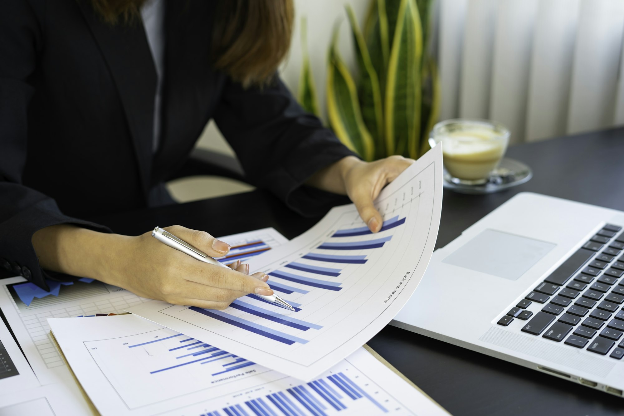 A female finance businesswoman checking the company's financial capital report From graph paper At t