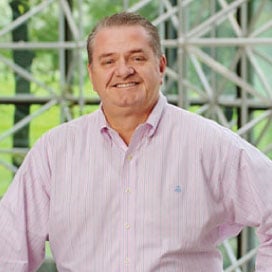 A man in a light pink button-up shirt exuding the confidence of an enterprise risk management consultant.