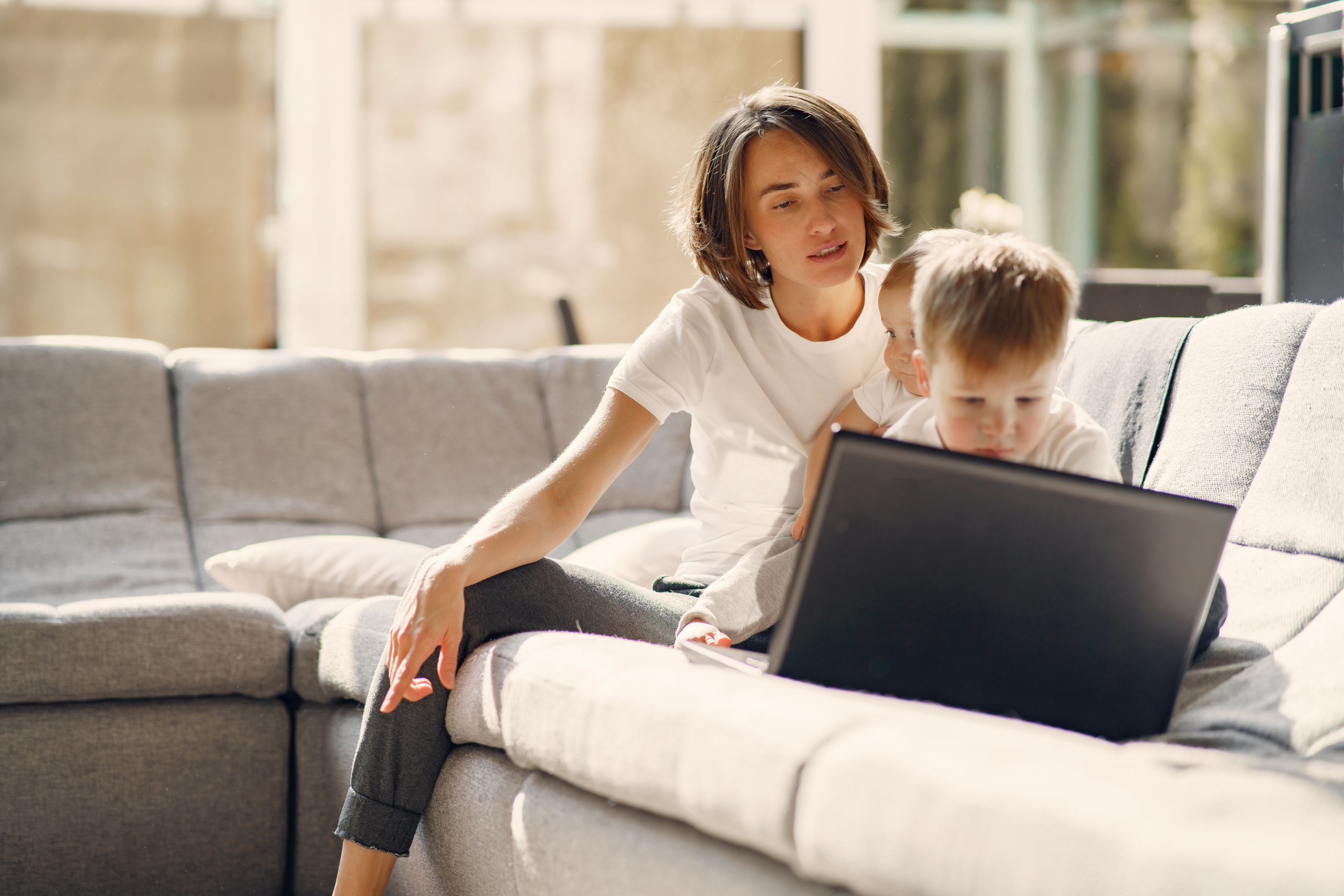 Mother working from home while child plays