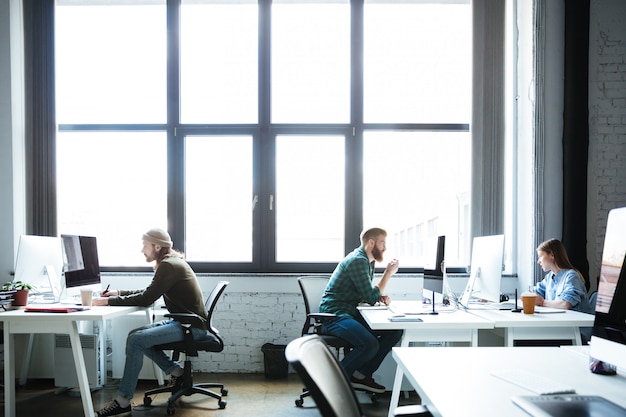 Three people working at desks providing top-notch risk management services in Florida.